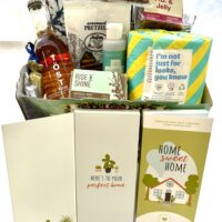 Move In Basket-contents: Home Sweet Home chocolate bar, snacks, reusable towels, toilet paper, & more.